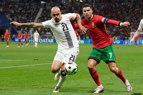 Cristiano Ronaldo and Vanja Drkusic battle for the ball 